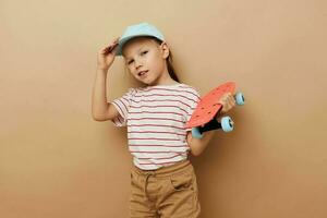 pretty young girl with a children's skateboard in hand smile isolated background photo