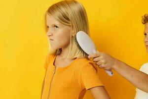 little girl combing blonde hair dissatisfaction photo