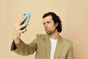 hombre en un traje posando emociones mirando a el teléfono aislado antecedentes foto