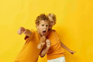 imagen de positivo chico y niña acurrucarse Moda infancia entretenimiento en de colores antecedentes inalterado foto