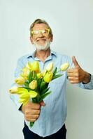 old man a bouquet of flowers with glasses as a gift light background photo