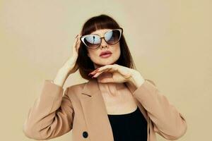 retrato de un mujer encanto rojo uñas modelo lujo Gafas de sol aislado antecedentes foto