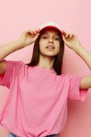 cheerful young girl with a cap on her head in a pink t-shirt photo