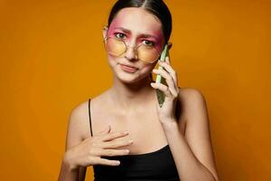 retrato de hermosa joven mujer con un teléfono en mano brillante maquillaje posando Moda emociones de cerca inalterado foto