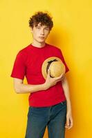 guy with red curly hair in a red t-shirt with a fashion hat yellow background unaltered photo