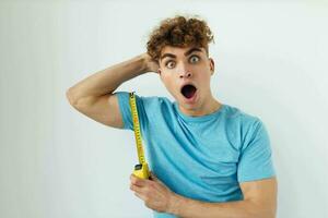 handsome young man emotions grimace measuring tape Lifestyle unaltered photo