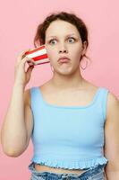 pretty girl drinking from a disposable glass close-up pink background unaltered photo