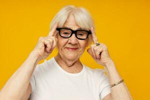 elderly woman in a white t-shirt wears glasses isolated background photo