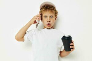 Photo portrait curly little boy talking on the phone with a black glass isolated background unaltered