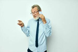 Portrait of happy senior man in a shirt with a tie with a phone technology cropped view photo