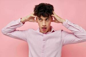 handsome guy in a pink shirt gesturing with his hands isolated background unaltered photo