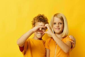 picture of positive boy and girl cuddling fashion childhood entertainment on colored background photo