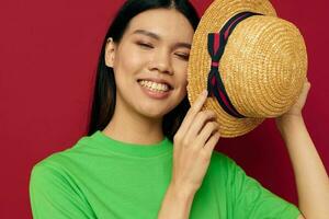 retrato asiático hermosa joven mujer en un verde camiseta gesticulando con su manos divertido rojo antecedentes inalterado foto