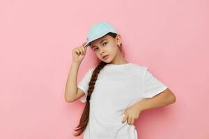 Portrait of happy smiling child girl posing white tshirt emotion pink background photo