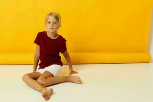 pequeño niña sentado en el piso amarillo antecedentes emociones foto