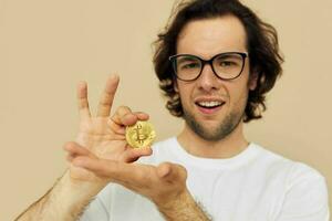 Attractive man in a white T-shirt with Bitcoin cryptocurrency beige background photo