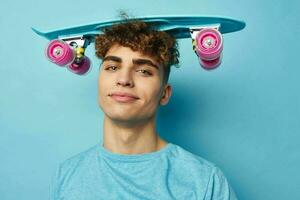 handsome young man blue skateboard in hand isolated background photo