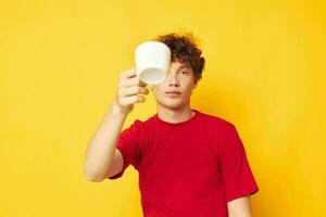 cute red-haired guy posing with a white mug and in the hands of a drink Lifestyle unaltered photo