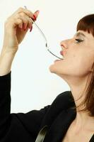 portrait of a woman in a black jacket a knife and a fork near the face isolated background photo