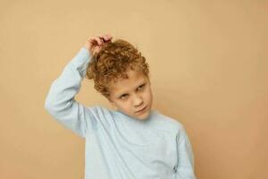 Photo of young boy in a blue sweater posing fun isolated background