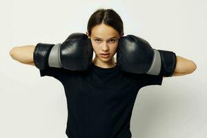 athletic woman in boxing gloves in black pants and a T-shirt fitness training photo