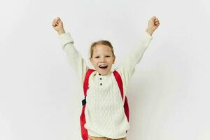 little girl school backpack with a hat on his head light background photo