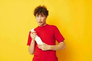 portrait of a young curly man detergents home care posing yellow background unaltered photo