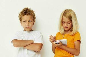 Cute stylish kids stand next to notepad pencil drawing emotions color background unaltered photo