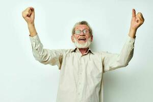 elderly man in shirt with hands raised up emotions light background photo