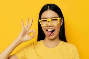 pretty brunette in glasses gesturing with hands copy-space yellow background unaltered photo