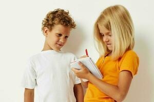 picture of positive boy and girl stand next to notepad pencil drawing emotions lifestyle unaltered photo