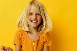 Young blonde girl in a yellow t-shirt smile posing studio childhood lifestyle unaltered photo