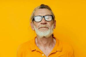 un mayor hombre con lentes en un amarillo camiseta con lentes de cerca foto