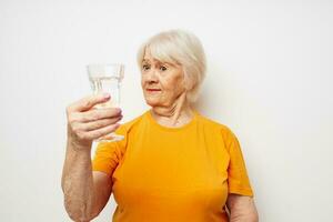 Cheerful elderly woman holding a glass of water health close-up emotions photo