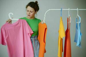 portrait of a young woman ironing clothes on a hanger wardrobe cropped view unaltered photo