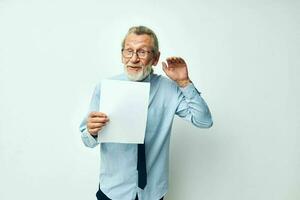 Photo of retired old man holding documents with a sheet of paper light background