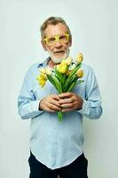 retrato de contento mayor hombre un ramo de flores de flores con lentes como un regalo ligero antecedentes foto