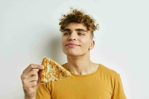 hermoso joven hombre comiendo Pizza posando de cerca estilo de vida inalterado foto