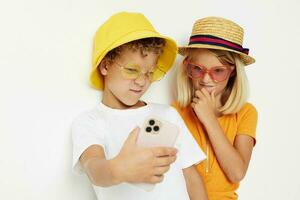 chico y niña con teléfono entretenimiento tecnología infancia foto