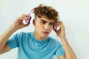 hermoso joven hombre en azul camisetas rosado auriculares Moda aislado antecedentes foto