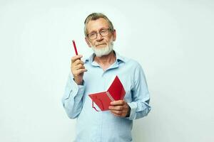 Photo of retired old man red notepad writing light background