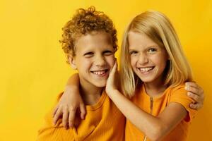 Cute preschool kids in yellow t-shirts standing side by side childhood emotions yellow background photo