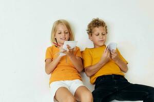 two joyful children lie on the floor with notepads and pencils childhood lifestyle unaltered photo