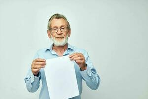 Photo of retired old man holding a sheet of paper copy-space posing isolated background