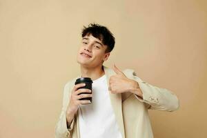 portrait of a young man black disposable glass in the hands of posing fashion light background unaltered photo