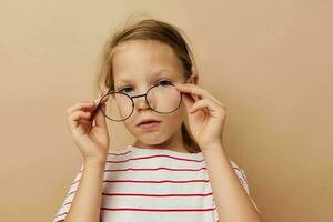 cute little girl round glasses posing beige background photo