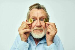 Photo of retired old man finance gold coins bitcoin near face light background