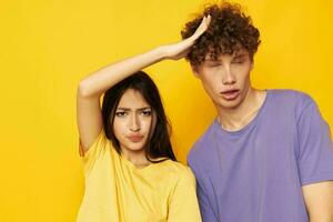 linda joven Pareja en vistoso camisetas posando amistad divertido amarillo antecedentes inalterado foto