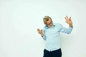 Senior grey-haired man in blue shirts gestures with his hands isolated background photo