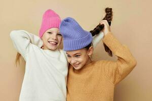 two funny little girls in colorful hats posing photo